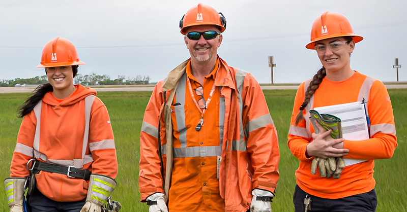 Harvey standing next to 2 female PLT apprentices smiling. 