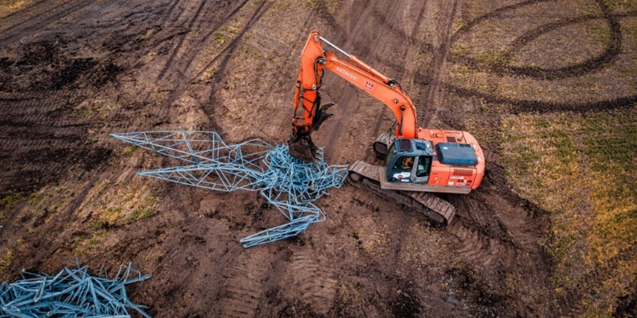 Excavator crushing old metal structures